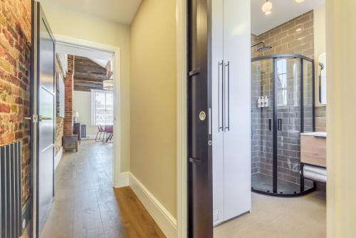 um corredor com uma porta que leva a uma cozinha com um lavatório em Oak & Poppy em Londres
