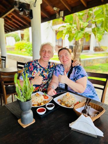 a man and woman sitting at a table with food at Moonstone Villas in Tangalle