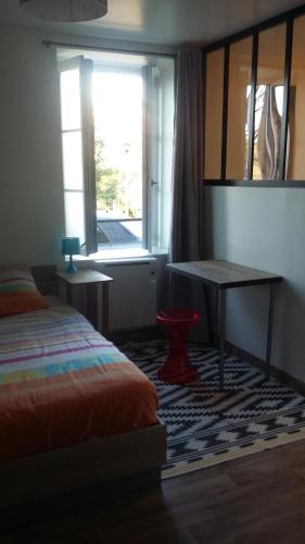 - une chambre avec un lit, un bureau et une fenêtre dans l'établissement Appartement cosy 25 m², à Limoges