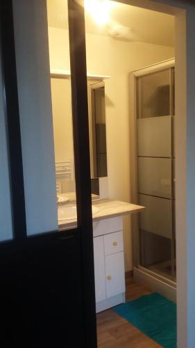 La salle de bains est pourvue d'un comptoir blanc et d'un lavabo. dans l'établissement Appartement cosy 25 m², à Limoges