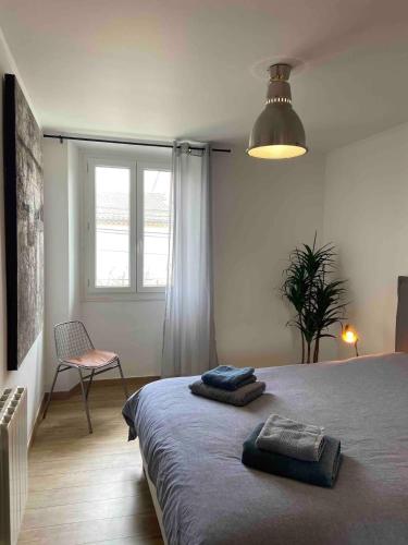 une chambre avec un lit, une chaise et une fenêtre dans l'établissement Appartement avec climatisation proche du centre, à Morières-lès-Avignon