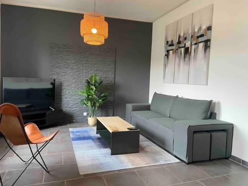 ein Wohnzimmer mit einem Sofa und einem TV in der Unterkunft Appartement avec climatisation proche du centre in Morières-lès-Avignon