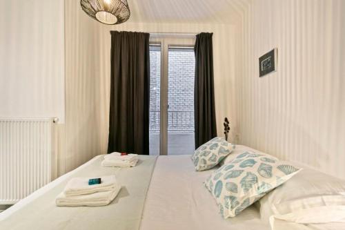 a bedroom with a bed with towels on it at Delightful family apartment at only 50 meters from the beach / Panne A Côte in De Panne