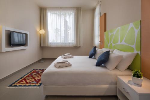 ein Schlafzimmer mit einem großen Bett und einem TV in der Unterkunft Desert Iris Hotel in Jerocham