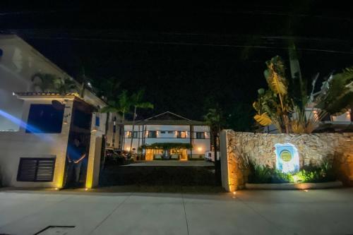 a large house at night with a yard at Hotel Ilhas da Grécia in Guarujá