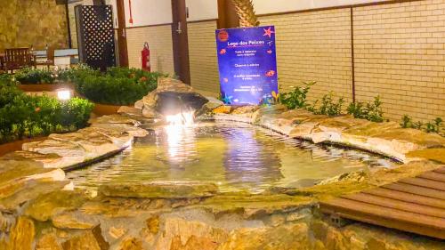 a small pond in a building with a bench at Hotel Ilhas da Grécia in Guarujá