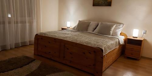a bedroom with a large wooden bed with two night stands at Akácfa Vendégház in Makó