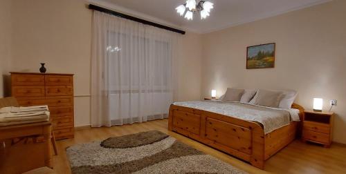 a bedroom with a large bed and a dresser at Akácfa Vendégház in Makó
