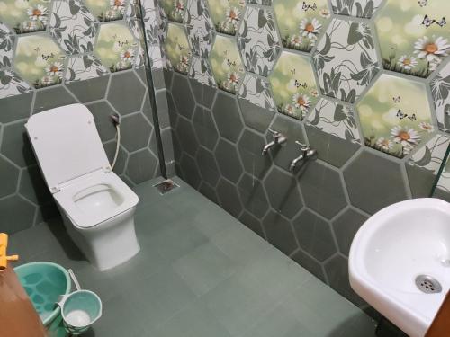 a bathroom with a toilet and a sink at Sri Sai Farm House in Puducherry