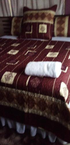 a bed with two white towels on top of it at Waltershort Guest House and Bed and Breakfast in Pietermaritzburg