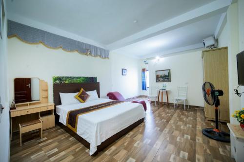 um quarto de hotel com uma cama e uma televisão em Family Transit 2 Hotel em Hanói