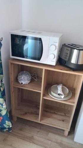 a microwave oven sitting on top of a wooden shelf at ELISABETH HOME Piata Mare in Sibiu