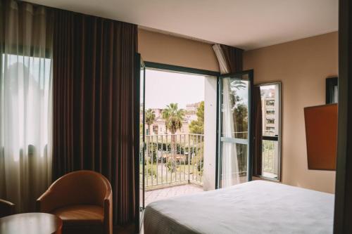 ein Hotelzimmer mit einem Bett und einem großen Fenster in der Unterkunft Hotel dei Cavalieri Caserta - La Reggia in Caserta