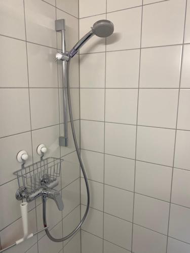 a shower head in a bathroom with white tiles at Bambi Lodge Ferienwohnung auf knapp 1400 m nahe Arosa in Peist