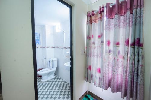 uma casa de banho com um WC e uma cortina de chuveiro em Family Transit 2 Hotel em Hanói