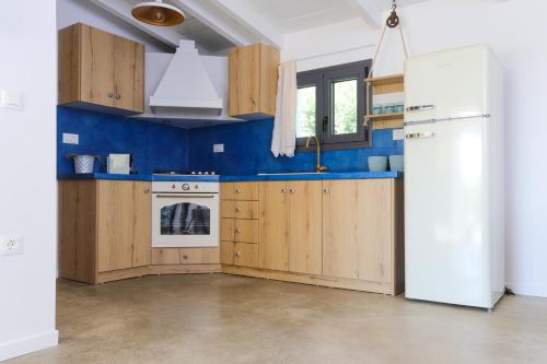 a kitchen with wooden cabinets and a white refrigerator at Lavender farm house in Nafpaktos