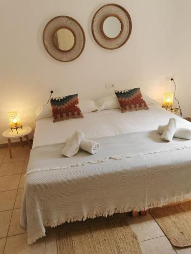 a bedroom with a large white bed with two pillows at Casa Nube in Sant Francesc Xavier