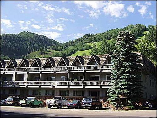 a large building with cars parked in front of it at Dean St Condos in Aspen