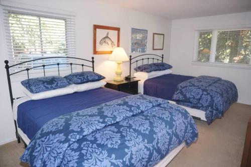 a bedroom with two beds with blue comforters at Dean St Condos in Aspen