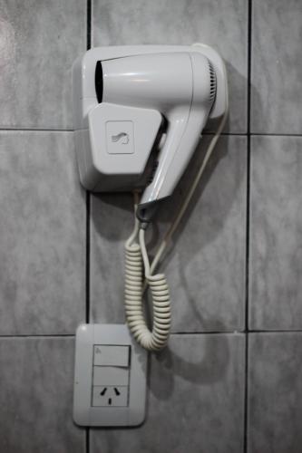 a white phone is hanging on a wall at Palo Rosa Lodge in Puerto Iguazú