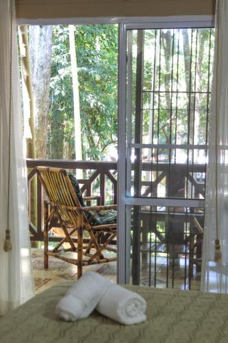 a towel laying on a bed in front of a window at Palo Rosa Lodge in Puerto Iguazú