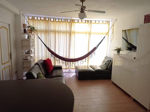 sala de estar con sofá y ventana grande en Clean and comfortable budget flat, en Fuengirola