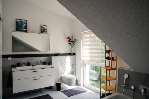 baño con lavabo y aseo y ventana en Panorama Suite 20, en Sinsheim