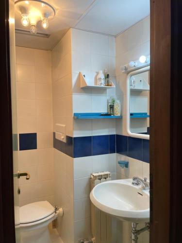 a bathroom with a sink and a toilet and a mirror at Appartamento Val di Luce in Abetone