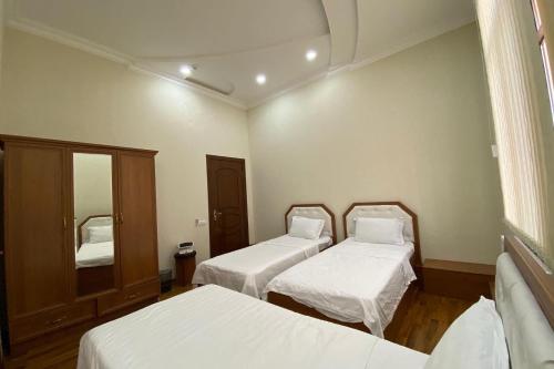 Habitación hospitalaria con 2 camas y espejo en MOUNTAIN VIEW SAMARKAND, en Samarkand
