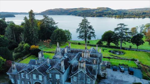an old castle with a lake in the background at The Lake House, Wansfell Holme, Windermere in Ambleside