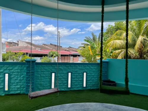 a swing in a playground with a view of a building at House of Happiness Homestay 幸福之家 in Bentong