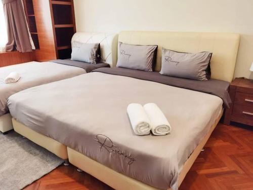 2 Betten in einem Zimmer mit Handtüchern darauf in der Unterkunft EASTERN ORIENTAL STRAIT QUAY MARINA LUXURY SUITE in Tanjong Tokong