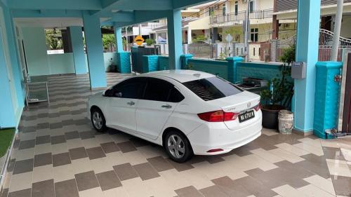 a white car parked in front of a building at House of Happiness Homestay 幸福之家 in Bentong