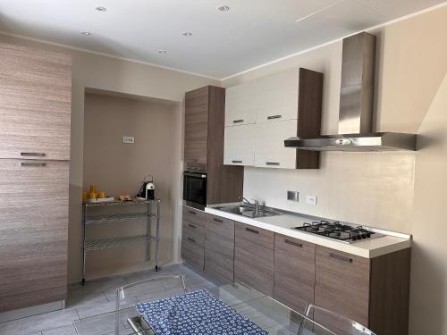 uma cozinha com armários de madeira e um forno com placa de fogão em A Due Passi - Sanremo Apartments em Sanremo