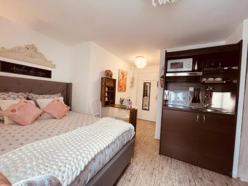 - une chambre avec un lit et un four micro-ondes sur une armoire dans l'établissement MamZelle Toutapié, studio quartier historique de Vannes proche Gare, à Vannes