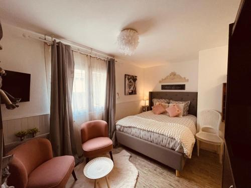 une chambre avec un lit et une chaise dans l'établissement MamZelle Toutapié, studio quartier historique de Vannes proche Gare, à Vannes