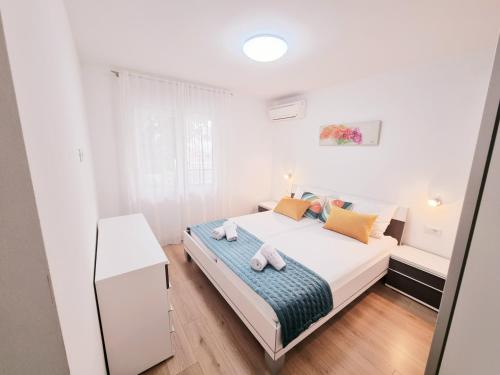 a bedroom with a bed with two towels on it at Apartman Maslina in Krk