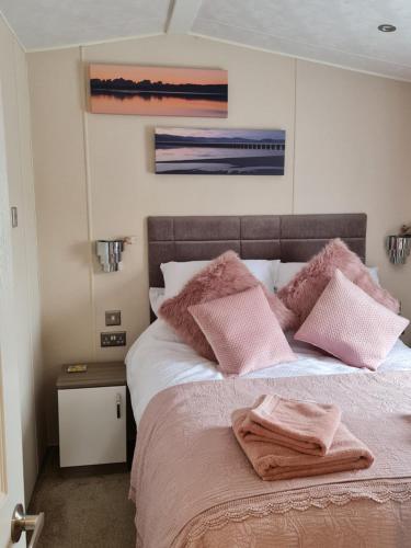una camera da letto con un letto con cuscini rosa di Nicks and Carmels by the Lake a Carnforth