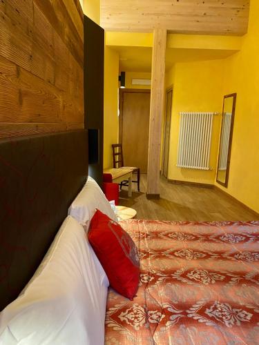 a bedroom with a bed with red and white pillows at Hotel Chaberton in Cesana Torinese