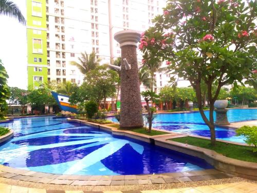 une grande piscine dans une ville avec de grands bâtiments dans l'établissement Tiny studio with pool, jogging track, gym and Mall, à Jakarta