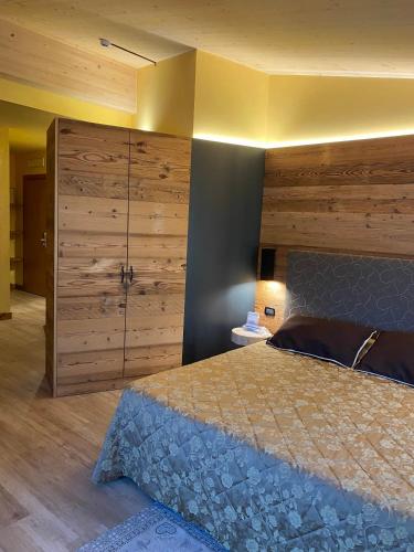 a bedroom with a bed and a large wooden wall at Hotel Chaberton in Cesana Torinese