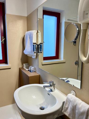 a bathroom with a white sink and a mirror at Hotel Chaberton in Cesana Torinese