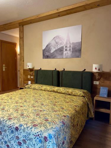 a bedroom with a bed with a floral bedspread at Hotel Chaberton in Cesana Torinese