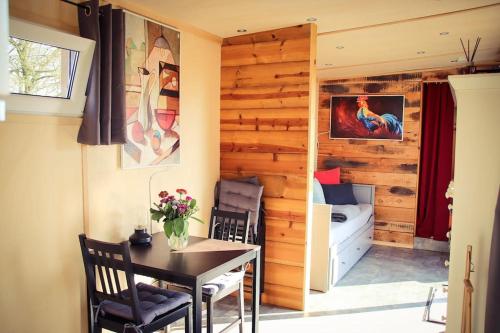 a room with a dining table and a bedroom at Tinyhouse Zirkuswagen- Kotten Kunterbunt in Nottuln