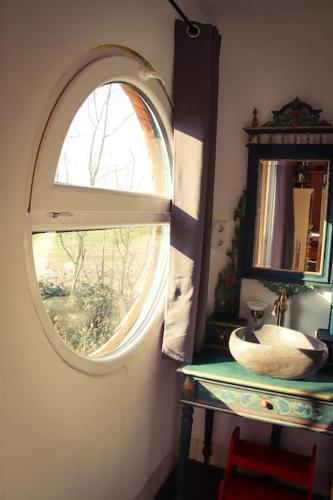 a bathroom with a round window and a sink at Tinyhouse Zirkuswagen- Kotten Kunterbunt in Nottuln
