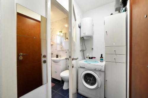 a bathroom with a washing machine and a toilet at Studio Apartment Aneta in Zagreb