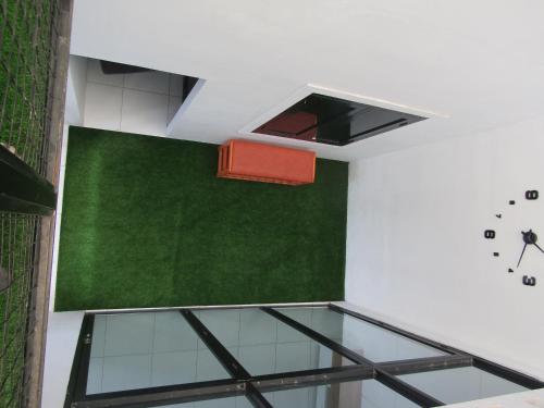 a room with a green wall and a clock at Rumah Kembar DI kawasan wisata lembang in Citeureup 1