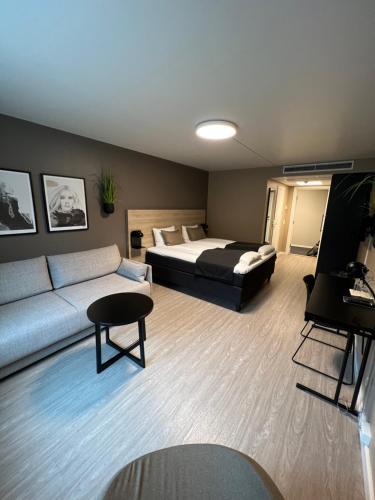 sala de estar con cama y sofá en Mosjøen Hotel, en Mosjøen