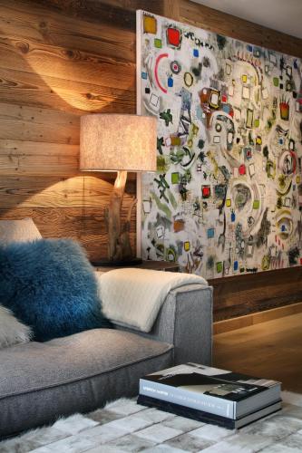 a living room with a couch and a wall covered in stickers at Megève centre in Megève