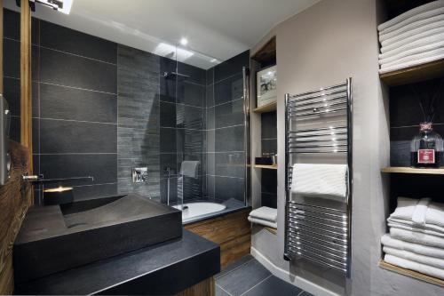 a bathroom with a black sink and a tub at Megève centre in Megève